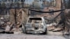 A burnt out car sits at the front of a house destroyed by bushfires in Winmalee in Sydney's Blue Mountains on October 18, 2013. 