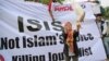 FILE - A Muslim woman releases a dove as a symbol of peace during a rally against the Islamic State group in Jakarta, Indonesia, Sept. 5, 2014.