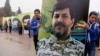 Lebanon's Hezbollah boy scouts carry a picture of Hezbollah commander Hassan al-Laqis during his funeral in Baalbeck, in Lebanon's Bekaa valley, Dec. 4, 2013. 