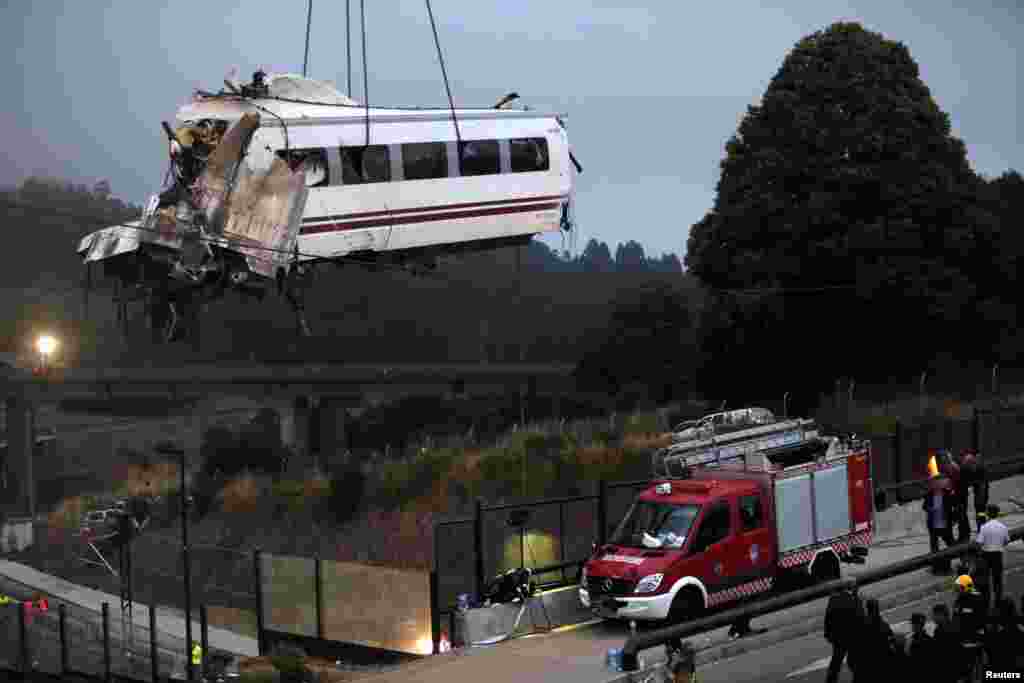 A crane removes a carriage from the tracks at the site of a train crash near Santiago de Compostela, northwestern Spain, July 25, 2013. 