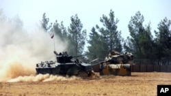 FILE - A Turkish army tank and an armored vehicle are stationed near the border with Syria, in Karkamis, Turkey, Aug. 23, 2016. Turkey now has its eyes on the Syrian city on Manbij it sees as critically important in its fight against Kurdish rebels.