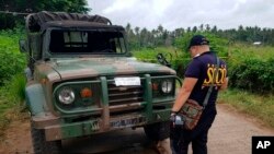 Un policier inspecte un véhicule au point de contrôle où une camionette a explosé le mardi 31 juillet 2018