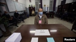 An electoral worker wearing a face mask for protection against the coronavirus disease (COVID-19), looks on at a polling station where Algerians vote in a constitutional referendum in Algiers, Algeria, Nov. 1, 2020.