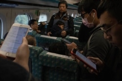 Travelers on a high speed train from Kaohsiung to Taipei read up on the post-election news near central Taiwan's Taichung city, Jan. 12, 2020