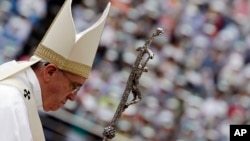 Pope Francis walks with his pastoral staff as he arrives to celebrate a mass at a soccer stadium in Daejeon, South Korea, Friday, Aug. 15, 2014.