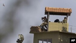 Turkish soldiers survey the border between Syria and Turkey from a military post near the Turkish village of Guvecci in Hatay province, June 28, 2011
