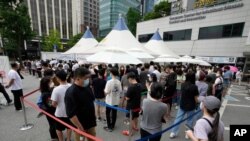 9일 한국 서울에서 신종 코로나바이러스 감염 검사를 받기 위해 줄 선 사람들.