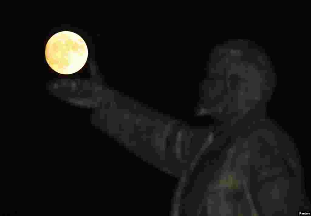 Bulan purnama "supermoon" terlihat di belakang patung pendiri Uni Soviet, Vladimir Lenin, di Baikonur, Kazakhstan.