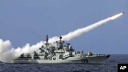 FILE - A Chinese warship launches a missile during a live-ammunition military drill held last year in the South China Sea. 