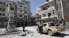 FILE - Rebel fighters inspect a site damaged by what activists said was shelling by warplanes loyal to Syria's President Bashar al-Assad in Jisr al-Shughour town, after the rebels took control of the area, April 26, 2015.