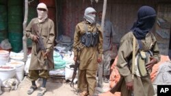 FILE - Armed Al-Shabab fighters patrol in Mogadishu, Somalia, June 29, 2009. 