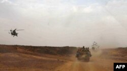 Sebuah helikopter tentara Perancis mengawal kendaraan yang membawa Perdana Menteri Mali, Moussa Mara, dari Gao ke Kidal (17/5).