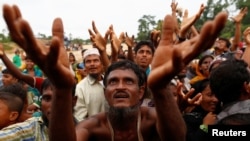 Para pengungsi Rohingya antri untuk mendapatkan bantuan makanan di kamp pengungsi Kutupalong, Bangladesh (9/9).