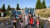 Orang dewasa dan anak-anak bermain air di Jefferson Park saat gelombang panas melanda Seattle, Washington, AS, 27 Juni 2021. (REUTERS/Karen Ducey)