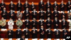 Delegates applaud as Chinese President Xi Jinping arrives for the opening session of China's National People's Congress (NPC) at the Great Hall of the People in Beijing, May 22, 2020. 