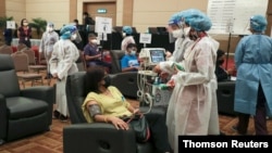 Medical workers speak to a woman under observation after receiving the coronavirus disease (COVID-19) vaccine, at Sunway Medical Centre, in Subang Jaya, Malaysia, March 12, 2021.
