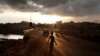 A boy stands on a road at dawn in Freetown, Sierra Leone.