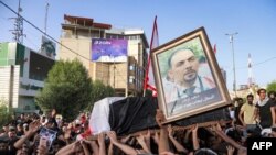 People chant slogans as they march with the body of renowned Iraqi anti-government activist Ihab al-Wazni (Ehab al-Ouazni) during a funerary procession in the central holy shrine city of Karbala on May 9, 2021.