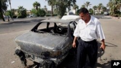 Seorang polisi lalu lintas Irak memeriksa mobil yang hancur ditembak tentara bayaran dari kontraktor keamanan swasta, Blackwater, di al-Nisoor Square, Baghdad, Irak, 25 September 2007. 