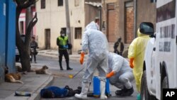 Health workers disinfect the body of a street vendor who was found dead by his neighbors in the Cerro San Miguel neighborhood of Cochabamba, Bolivia, July 25, 2020.