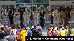 加利福尼亚国民警卫队成员站在洛杉矶的抗议者前方。(2025年6月9日)