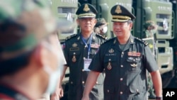 Cambodian Prime Minister Hun Sen's son, Lt. Gen. Hun Manet, right, arrives for handing over ceremony at National Olympic Stadium in Phnom Penh, Cambodia, Thursday, June 18, 2020. (AP Photo/Heng Sinith) 