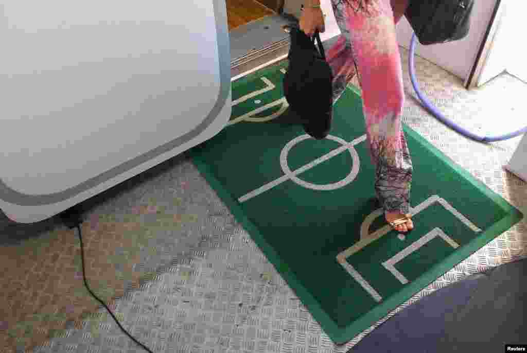 Karpet menyerupai lapangan sepakbola ditempatkan di pintu keluar pesawat di bandar udara Belem, Brazil (15/6).&nbsp;(Reuters/Yves Herman)