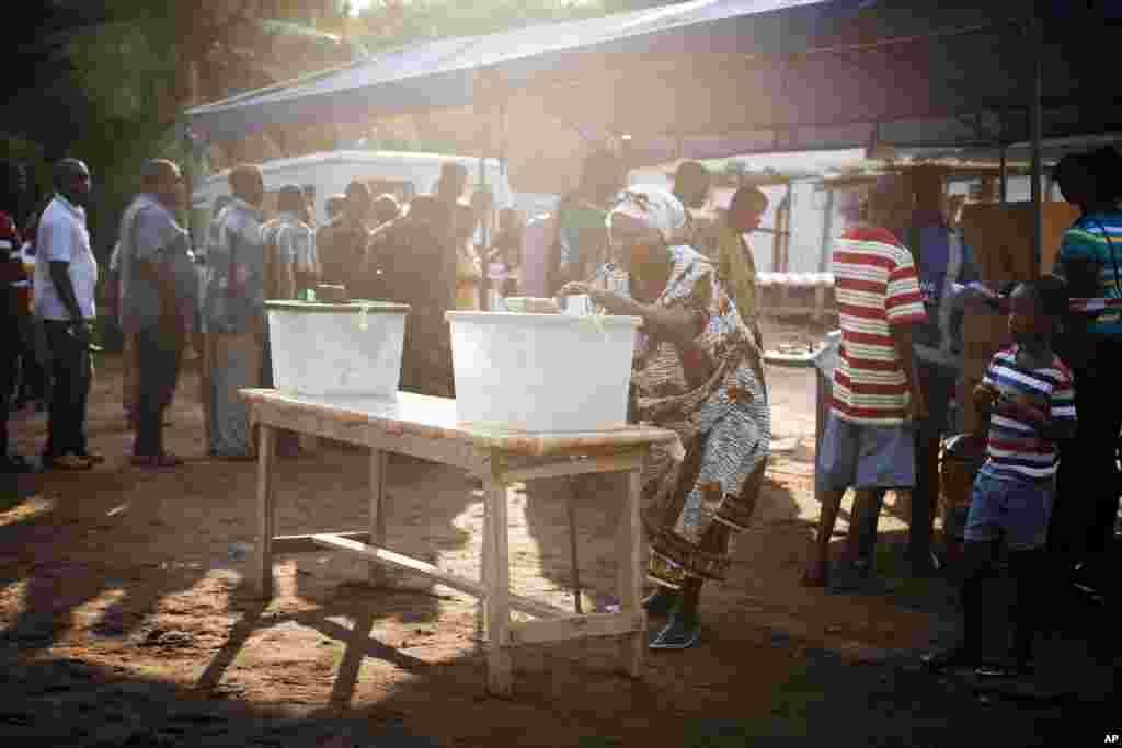 A woman casts her vote for the presidential election at a polling station in Accra, Ghana, December 7, 2012.
