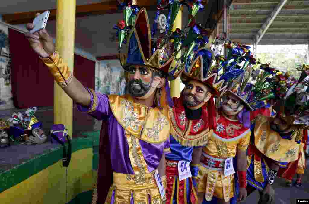 Penitents wearing masks, known locally as "Morions", take a selfie during the start of Holy Week celebrations in Mogpog, Marinduque in central Philippines.