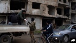 Припадник на новите вооружени сили, поранешен бунтовник кој учествуваше во соборувањето на владата на Башар Асад, проверува лична карта на лице на контролен пункт во областа Калидија, Хомс, Сирија, на 1 јануари 2025 година.