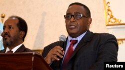 Somalia Prime Minister Omar Abdirashid Ali Sharmarke, right, flanked by Somalia's President Hassan Sheikh Mohamud, addresses delegates in the capital Mogadishu, Dec. 17, 2014. 