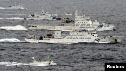 Pesawat pengintai Angkatan Laut China, Haijian No. 66 (tengah) melaju melewati dua kapal penjaga pantai Jepang di sekitar pulau-pulau sengketa di Laut China Timur (foto: dok). 