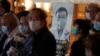 People wearing masks, attend a vigil for Chinese doctor Li Wenliang, in Hong Kong, Friday, Feb. 7, 2020. 