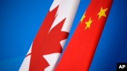 Bendera Kanada dan China terlihat dalam acara dialog Strategi Ekonomi dan Keuangan China-Kanada pertama di Beijing, 12 November 2018. (Foto: via AP)