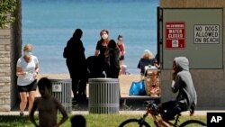 Signs are seen at Clark Street Beach during COVID-19 as people gather in Evanston, Ill., June 23, 2020.